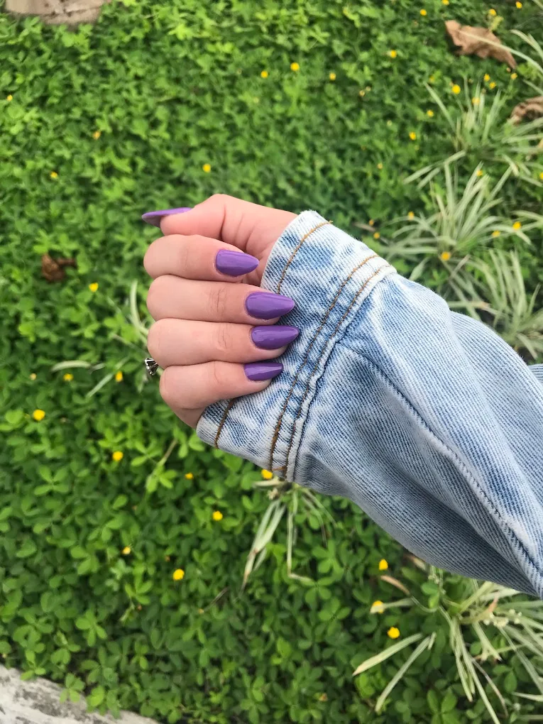 Unhas roxas com manga de jaqueta jeans